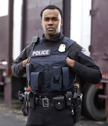 Officer standing with hands under his vest